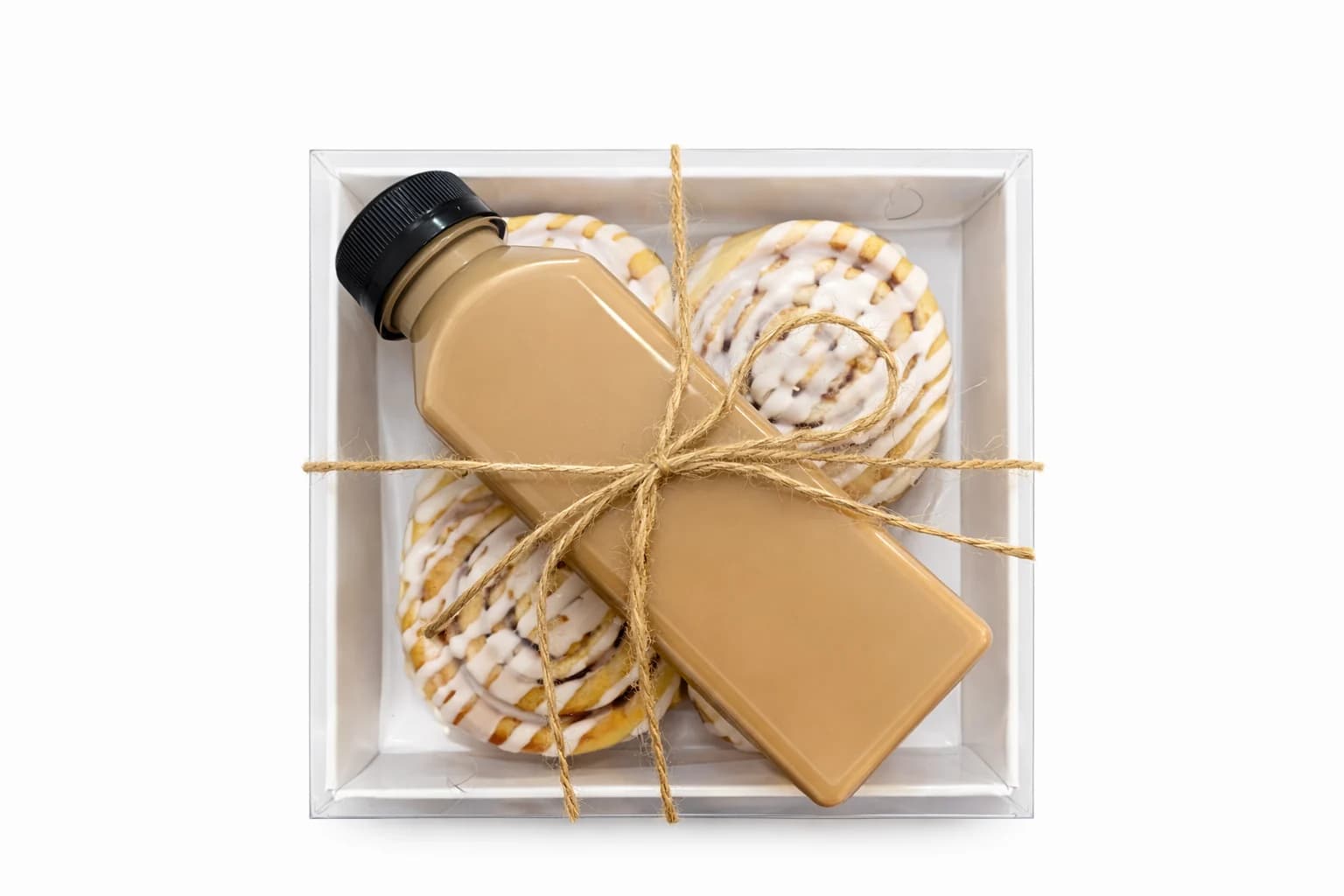A Sugar and Crumbs box of iced cinnamon buns with bottled iced coffee, packed for delivery